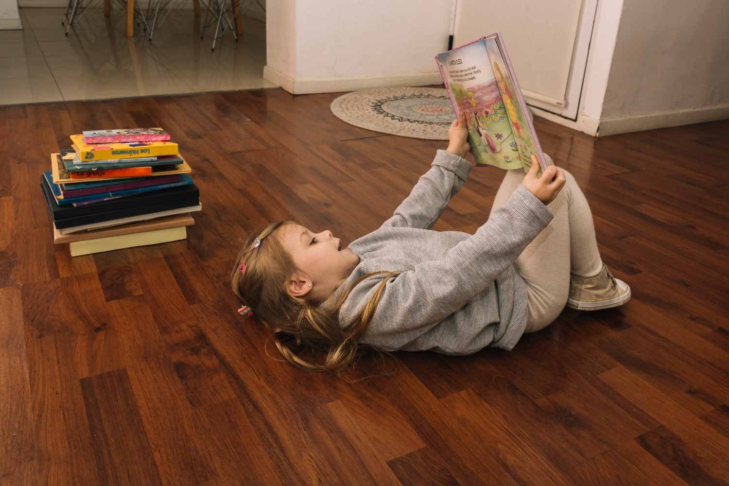 Girl reading a book while lying on the floor