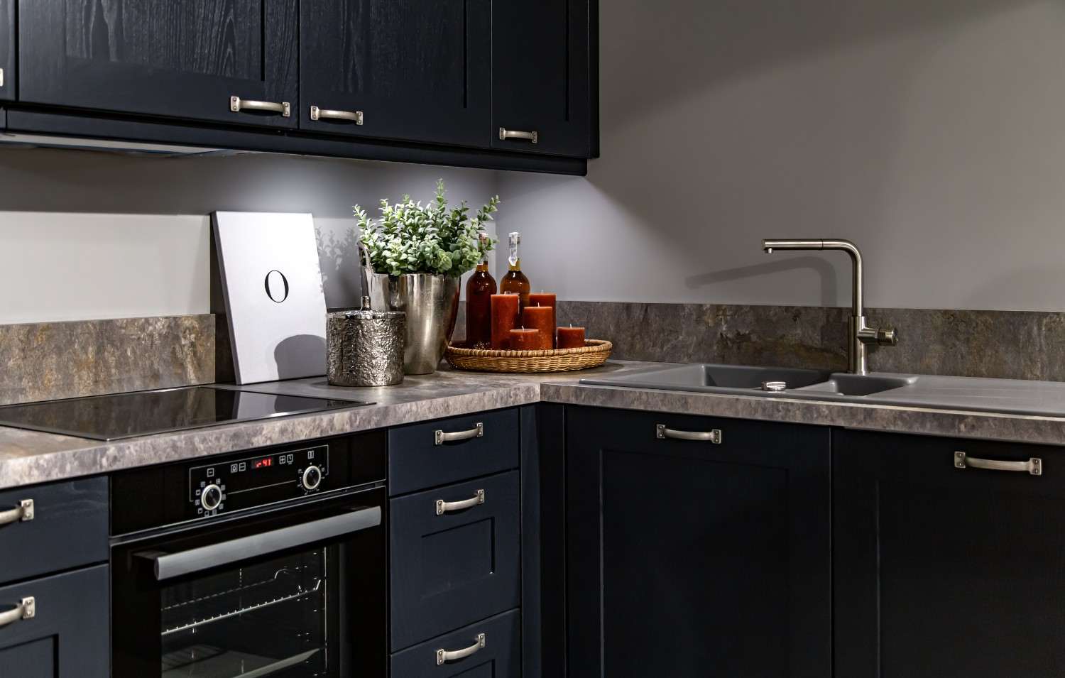 Dark navy shaker kitchen cabinets with a stone-look countertop