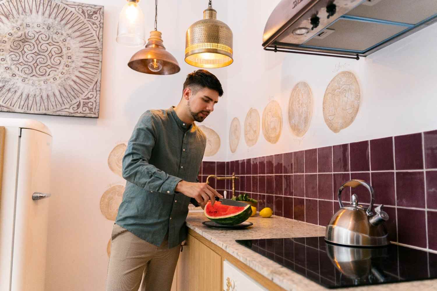 Man cutting watermelon in a kitchen