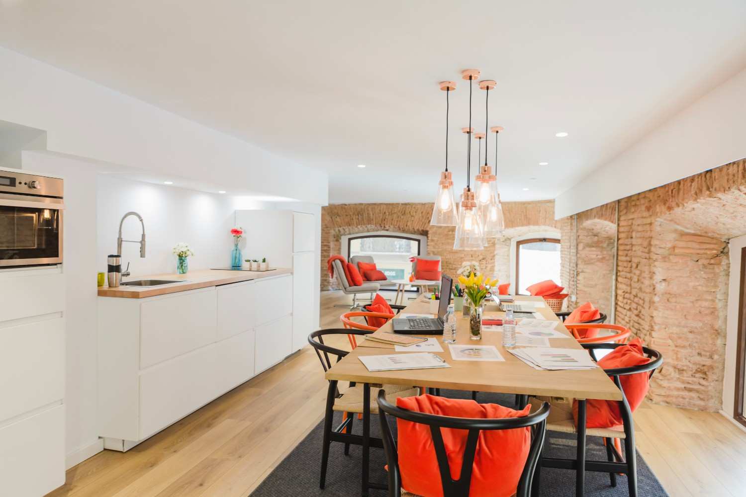 Bright open kitchen with white cabinets and a long dining table