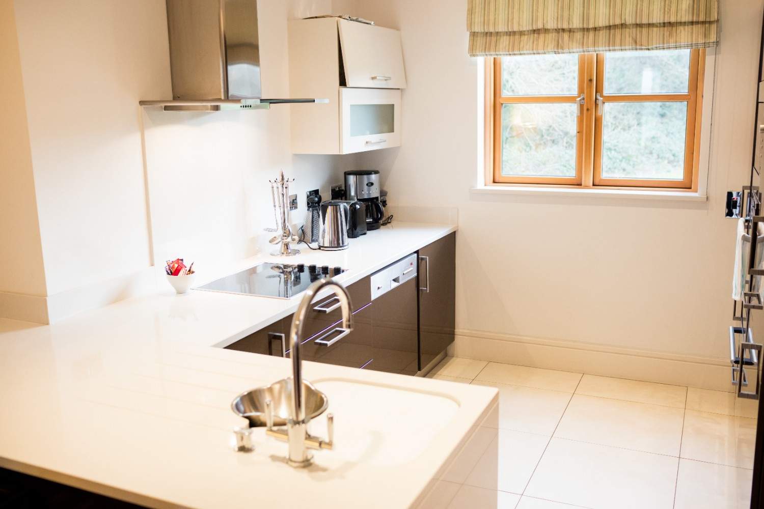 Compact L-shaped kitchen layout with white countertops and a window